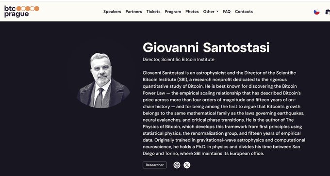 The image features a webpage with a black background and white text. The title of the webpage reads "Prague Prague", indicating that this event is taking place in Prague, Czech Republic. The main focus of the webpage is an interview with Giovanni Santostasi, who is described as an astrobiologist and director of the Scientific Bitcoin Institute. The image also includes a photo of Giovanni against a black background, which further emphasizes his presence at the event.