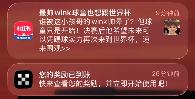Two iPhone notifications are displayed on a red background: the top notification from "小红书" (Xiaohongshu) reads "最帅 wink 球童也想踢世界杯" (The most handsome wink ball boy also wants to play in the World Cup) from 9 minutes ago, and the bottom notification shows "您的奖励已到账" (Your reward has arrived) from 26 minutes ago, with the Xiaohongshu post referencing World Cup prediction prizes and daily $USDG staking rewards matching the reward notification.