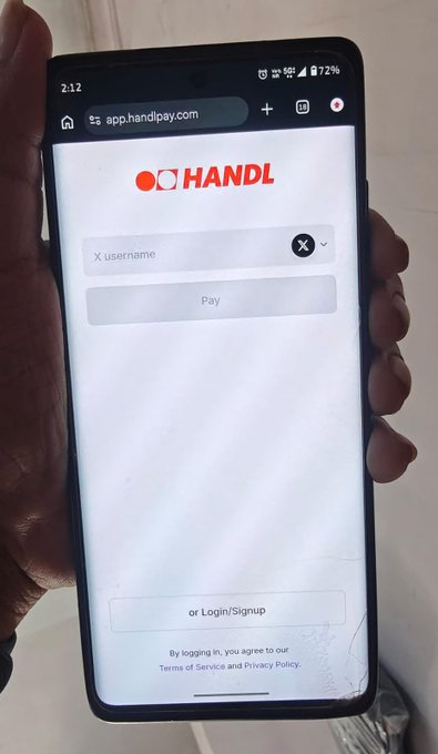 A hand holds a smartphone displaying the HANDL app login/signup screen at app.handlpay.com, with a time of 2:12 and battery at 72%.