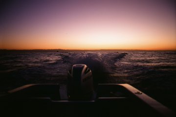 The image shows a boat sailing across an ocean at sunset, with waves in front of the boat. There are no texts or other objects in the photo that suggest any specific context or information related to Hyper liquid NFTs. It appears to be a natural scene focused on the calmness and beauty of the sunset and the waterscape surrounding it.