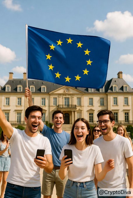A group of joyful people celebrating outdoors in front of a grand European-style building, with one man waving a large European Union flag, while others hold smartphones and cheer.