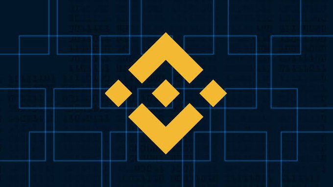 The Binance logo, a yellow geometric diamond design, displayed on a dark blue background with a grid pattern and faint text.