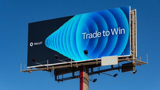 A billboard displays an ad for "WALLET" with the slogan "Trade to Win" against a blue background with a swirling cone design.