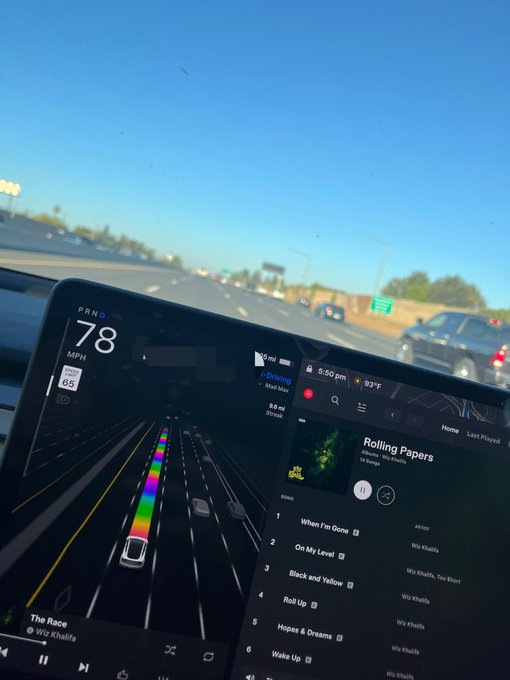 Inside a Tesla driving at 78 MPH on a highway, the touchscreen displays music by Wiz Khalifa ('Rolling Papers' album) and a navigation visualization, with the time 5:50 pm.