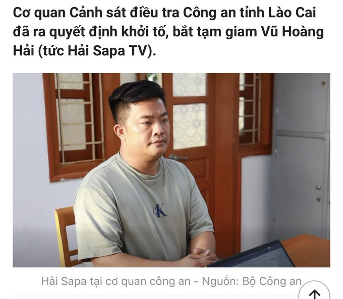A Vietnamese news article showing a photo of Vu Hoang Hai (Hai Sapa TV) at a police station, with text stating he was prosecuted and detained by Lao Cai Province Police.