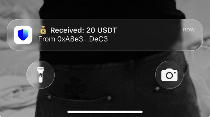 A screenshot of a crypto wallet notification showing 'Received: 20 USDT From 0xA8e3...DeC3' displayed over a black background showing a person's jeans.