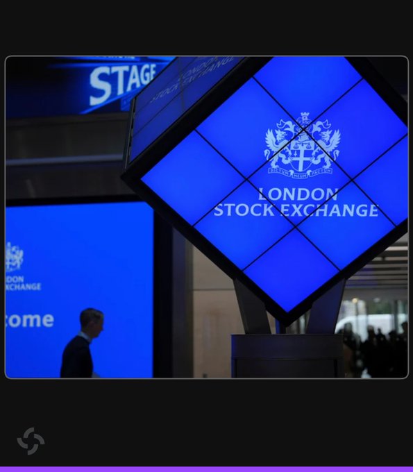 An illuminated, diamond-shaped London Stock Exchange sign with the "LONDON STOCK EXCHANGE" text and crest glows blue inside the building's lobby, where a man in a suit walks past. The image relates to the announcement that the London Stock Exchange plans to launch overnight trading in 2027 to compete with 24/7 crypto markets.