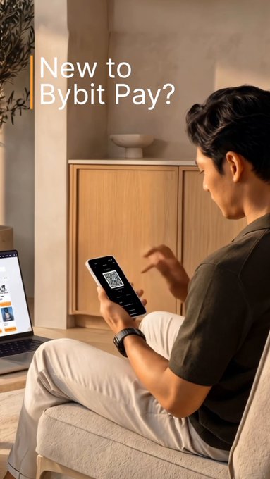 A man sits on a couch looking at his smartphone, which displays a QR code, with a laptop nearby—visually capturing the easy, in-app experience promised by the "New to Bybit Pay?" promotion offering a 2.50 USDT coupon for first-time crypto payments.