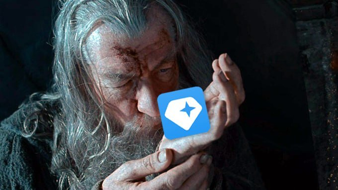A close-up of the character Gandalf from a film, holding his hands out with an overlaid blue 'g' logo icon.