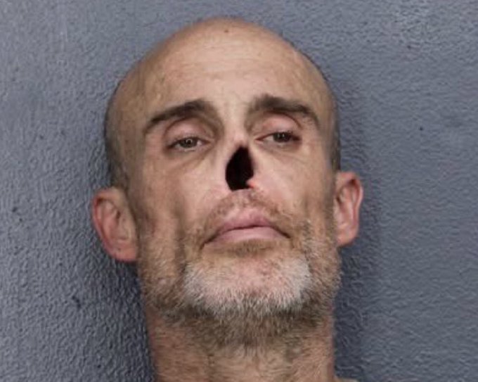 A mugshot-style close-up of a bald, gray-bearded man with what appears to be a missing or severely damaged nose, aligning with the meme's "NOSELESS GHOUL" caption and the $GHOUL ticker reference, with the contract address 0x2b3b89eFc36948Ab12840AdB62f672d92990921b displayed alongside the image.