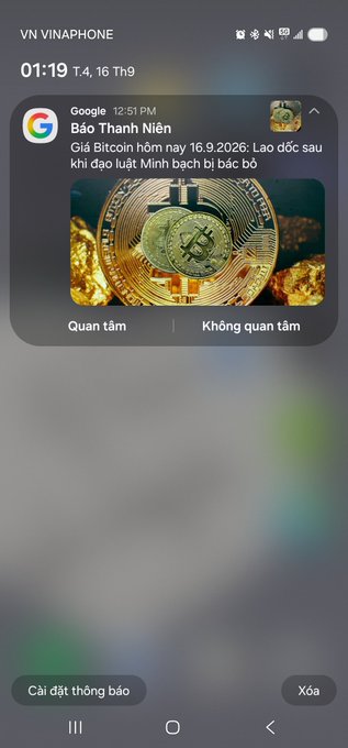 A smartphone screenshot from VN VINAPHONE at 01:19 showing a Google notification in Vietnamese about Bitcoin's potential crash and a Lao reader article.