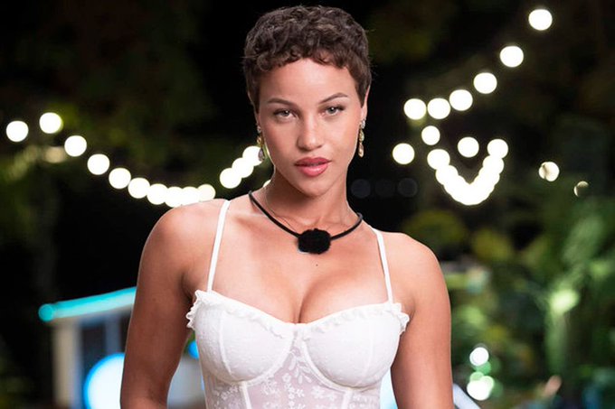 The image shows a woman with short curly hair wearing a white lace corset-style top, gold earrings, and a black pendant necklace, set against a backdrop of twinkling string lights and greenery.

Connection to "SOL looks good here": The image appears to be a still from a reality TV show (likely Love Island), but there is no direct relationship to the cryptocurrency ticker SOL (Solana) mentioned in the post. The caption seems to use the unrelated image as an eye-catching visual accompaniment to a crypto price analysis.