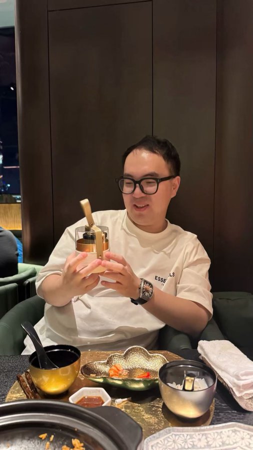 A man wearing glasses and a white t-shirt sits at a restaurant table, joyfully holding up a glass container of dessert with a spoon inside. The caption critiques Bybit (tagging @Bybit_Official and @benbybit) for allegedly failing to pay out the $7 million prize money from their 2022 WSOT futures trading competition, suggesting the image symbolizes the deserved outcome of their actions.