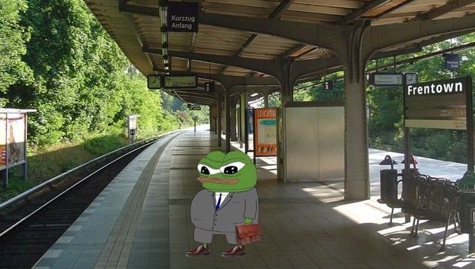 A Pepe the Frog character wearing a gray business suit and holding a red briefcase stands on a train platform labeled 'Erentown' (with German sign 'Kurzzug Anfang' visible).