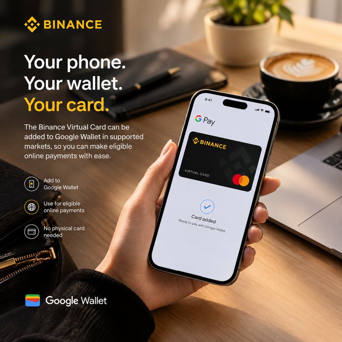 A person holds a smartphone displaying the Google Pay app with a Binance Virtual Card successfully added, shown against a cozy café scene with a latte and notebook. The Binance-branded promotional graphic advertises the ability to add the virtual card to Google Wallet for seamless online payments without needing a physical card.