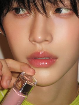 A close-up beauty shot of Wonbin holding a tube of glossy pink lip product near his lips, paired with the caption "Ether & #Wonbin" highlighting the dreamy, ethereal aesthetic of the image.