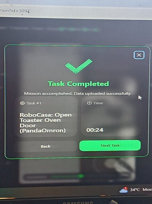 A computer screen displays a 'Task Completed' message for 'Task #1: RoboCasa: Open Toaster Oven Door (PandaOmron)' completed in 00:24 seconds.