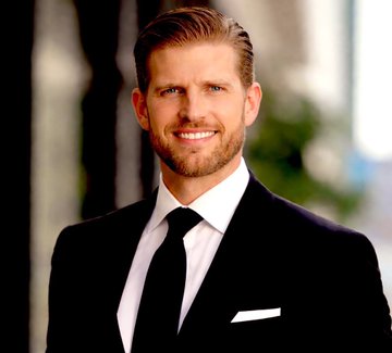 Eric Trump is pictured in a black suit and tie, smiling confidently, accompanying his statement expressing strong optimism ("bullish") about Bitcoin.