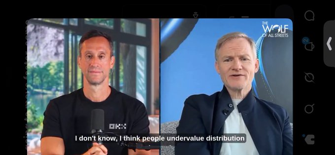 Screenshot from 'The Wolf of All Streets' podcast interview featuring two men in a split-screen format, with subtitle reading 'I don't know, I think people undervalue distribution'.