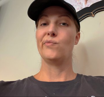 A woman wearing a black cap and dark gray t-shirt takes a close-up selfie with a pursed-lip expression, apparently sharing "farewell" photos as a humorous post while donating her social media accounts and a "diamond hand SuperYeti" token to friends.