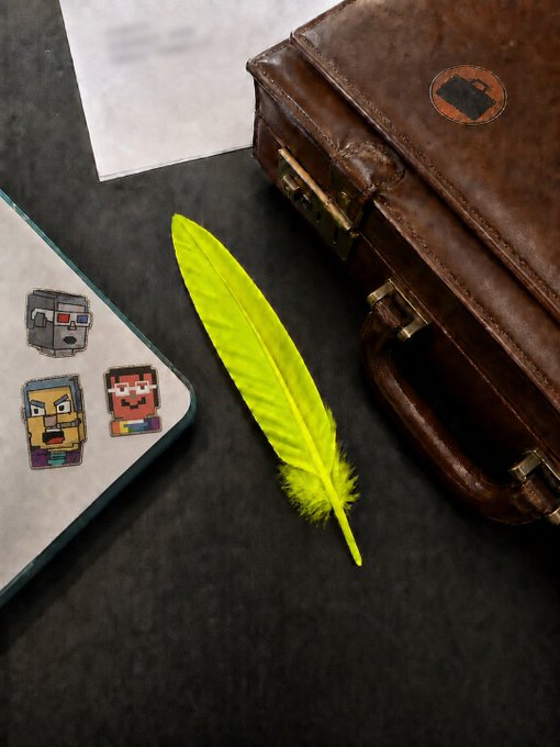 A flat lay shows a bright yellow feather, a brown leather briefcase, a notebook with pixel art stickers, and papers on a dark surface.