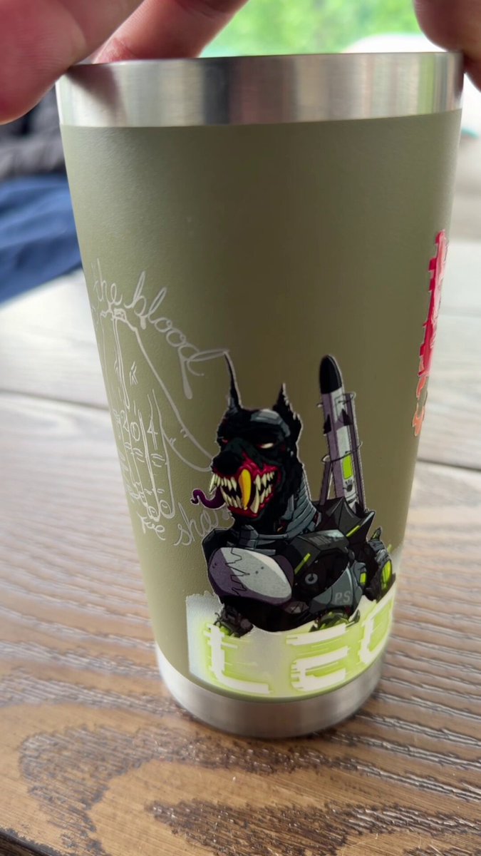 The image features a green cup with a cartoon character design, including a dog and a rocket ship, sitting on top of a wooden table. The cup has a sticker that says "LEO" on its side. The text in the image reads "PFP evolution over the last 4 years @MutantHounds @MH_Inscriptions @BoredApeYC".