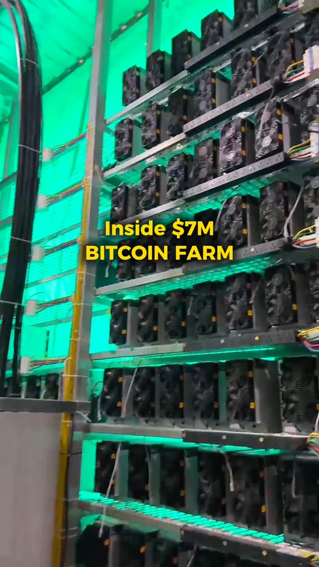 The image shows a warehouse with rows of computer parts, specifically bitcoin mining components like blocks and chips, stored together. A sign inside the warehouse advertises that these items are for sale at $7M Bitcoin Farm, indicating their high value within the market. The focus on this collection of hardware signifies its importance to the cryptocurrency world and the miners who rely on it for financial gains.