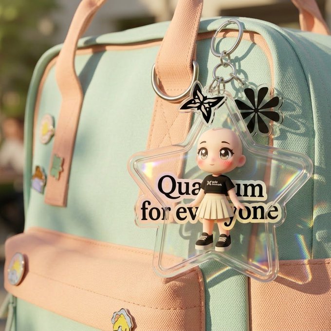 A clear star-shaped acrylic keychain featuring a bald cartoon character reading 'Quantum for everyone' hangs from a mint green backpack with pastel pink straps.