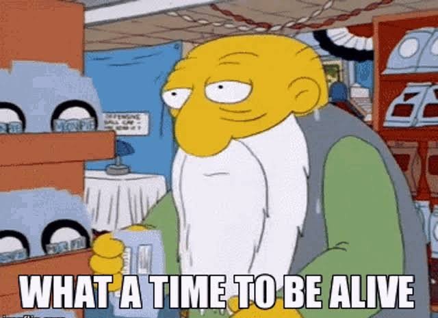 A meme featuring Mr. Burns from *The Simpsons* holding a small item in a store, captioned "WHAT A TIME TO BE ALIVE," sarcastically reflecting the bleakness of the crypto bear market as projects shut down and even CZ hints at further price declines.
