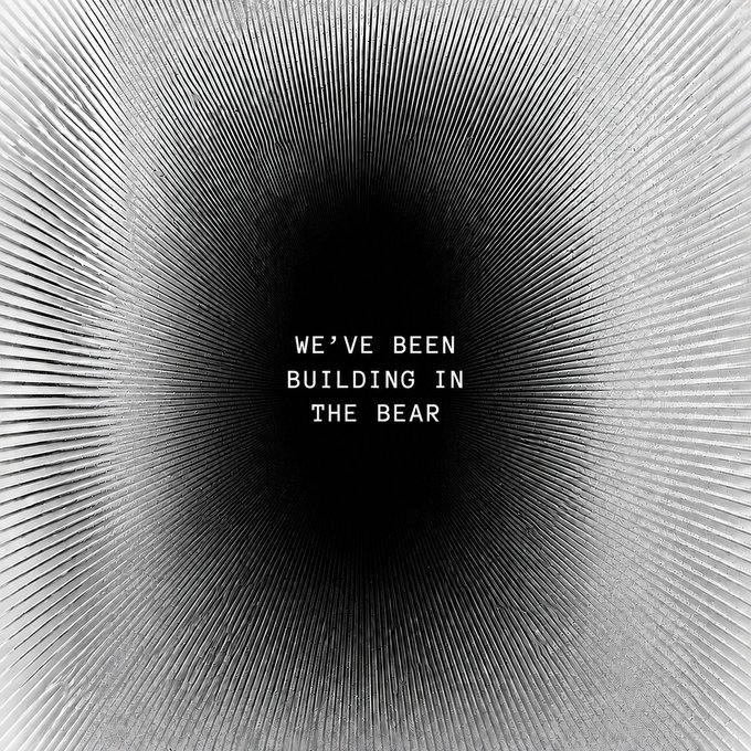 A black and white graphic with radiating lines forming a tunnel effect, containing the text 'WE'VE BEEN BUILDING IN THE BEAR' in the center.