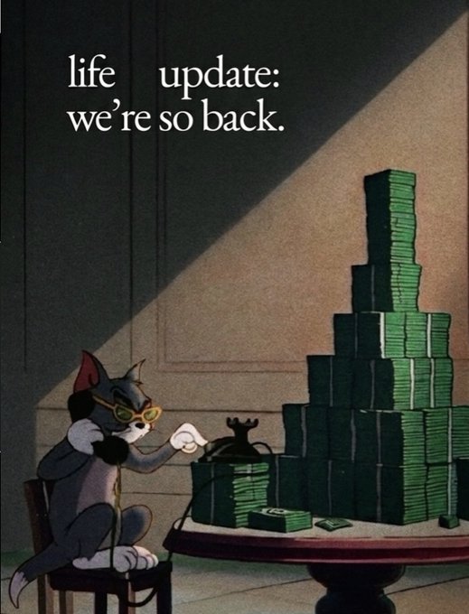 A Tom and Jerry cartoon meme showing Tom the cat wearing yellow sunglasses and typing on a vintage typewriter next to a large pyramid stack of money, with text reading "life update: we're so back."