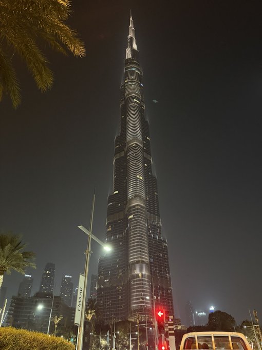 A nighttime photograph of the Burj Khalifa skyscraper illuminated against the dark sky in Dubai, UAE.