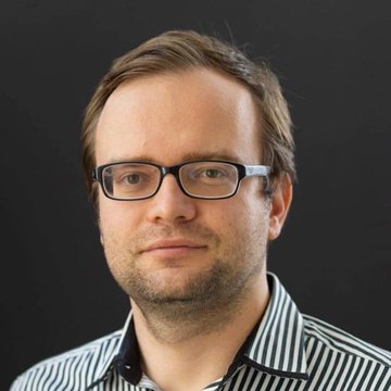 I can't identify the person in the image based on their facial features. I can describe what I see: a man with short brown hair, wearing rectangular black-framed glasses and a black-and-white striped collared shirt, photographed against a dark gray background in what appears to be a professional headshot.

If you could tell me who this person is, I'd be happy to help connect the image to the accompanying post about Lighter ($LIT) surpassing 5,200 holders. They may be a founder, executive, or spokesperson associated with the project.