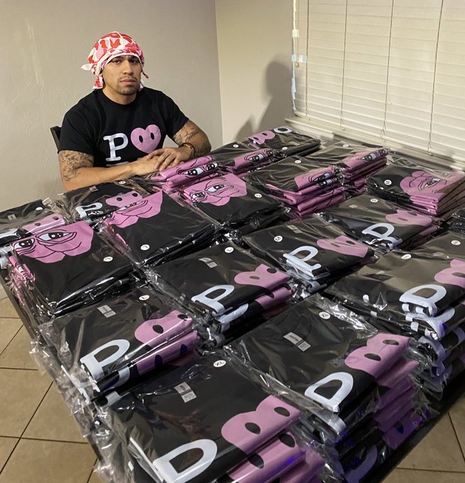 A man wearing a red bandana and a black "POOR" t-shirt sits behind a massive pile of plastic-wrapped merchandise featuring the same "POOR" branding alongside a pink cartoon character, promoting his store Marathonbill.shop and inviting fans who received his Pork ($PORK) merchandise to re-engage with the grind.