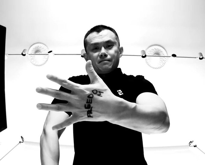 A black-and-white photo shows a man extending his hand toward the camera, with the word "FREEDOM" written across his palm, visually echoing the post's message "Freedom of Money" and the Binance-themed call for financial freedom.