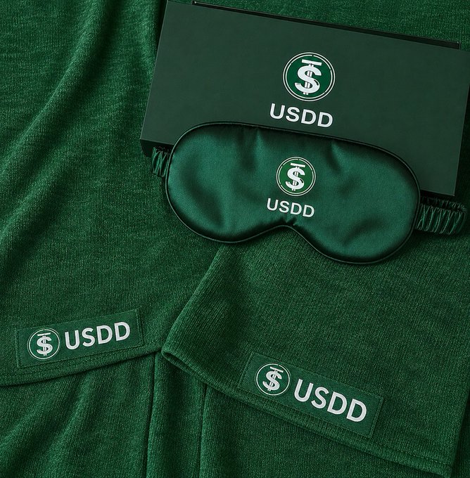 A green sleep mask, box, and fabric patches all branded with the USDD cryptocurrency logo.