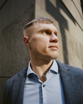 A blonde man in a blue blazer and light shirt stands outdoors against a stone wall, looking off to the side in a contemplative pose. The serious, thoughtful portrait complements the post's discussion of a significant legal precedent regarding cryptocurrency mixers and money laundering, particularly the Roman Sterlingov/Bitcoin Fog case before the DC Circuit Court.