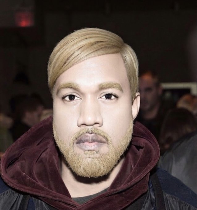 A close-up photo of a young man with blond hair swept to the side, a blond beard, wearing a maroon hoodie, at what appears to be an indoor event.