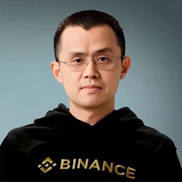 A man wearing glasses and a black Binance-branded hoodie poses against a gray background. The image, paired with a bullish quote about countries printing unlimited money to buy Bitcoin, highlights Binance's founder CZ making a strongly pro-crypto market call.