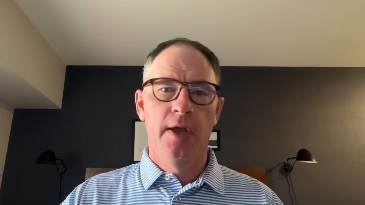 The image shows a man wearing glasses, standing against a wall with two lamps behind him. He appears to be looking directly at the camera while speaking into a microphone. The caption of the image reads "THEY CAN'T STOP XRP REPRICING: The Institutional Secret Ripple Is Hiding (Includes Paid Promotion) Watch The Full Youtube Video Here: youtu.be/-hv2U1Yxg2o". This suggests that there is an advertisement or promotional video related to cryptocurrency, specifically about the Ripple Ripple Chain, which might be discussing its benefits and features.