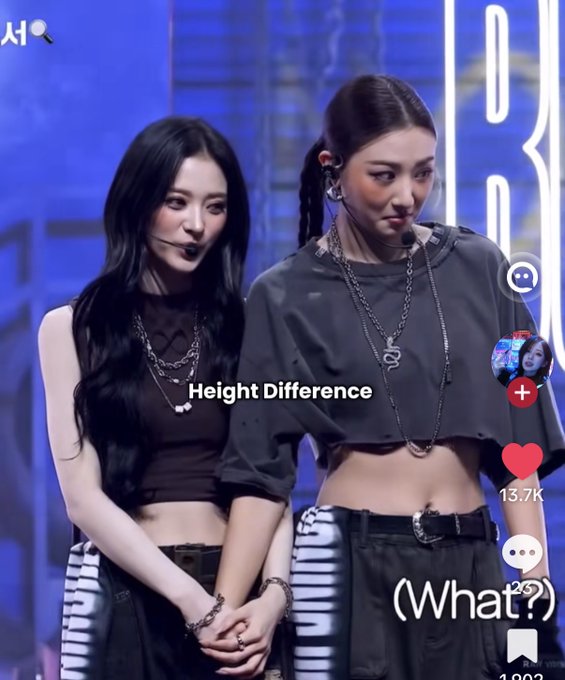 The image appears to be a TikTok screenshot showing two female K-pop performers on stage, with overlaid text reading "Height Difference" and "((What?))" and engagement metrics showing 13.7K likes and 2.3K comments. Based on the post's reference to #woona and the performers' styling, this likely features LOONA members Heejin and Hyunjin, whose contrasting statures have become a popular topic among fans.
