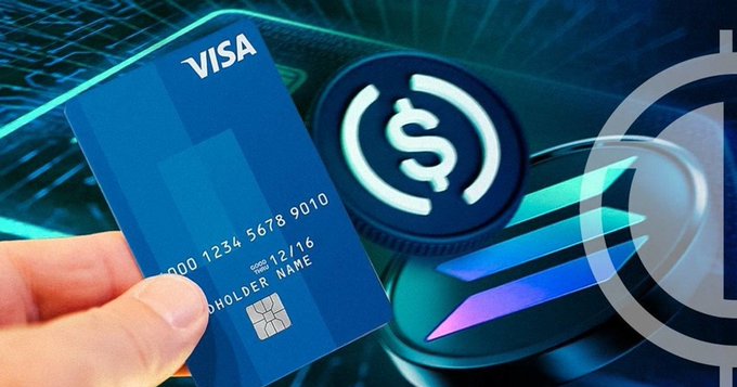 A blue Visa credit card (showing number "000 1234 5678 9010") is held in front of a glowing USDC stablecoin logo, visually representing Visa's launch of stablecoin-based payouts via Visa Direct. The pairing of the familiar payment card with the digital dollar symbol illustrates how traditional Visa payment infrastructure is now being integrated with USDC for near-instant global payouts across 180+ countries.