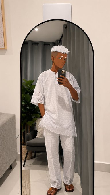 A mirror selfie of a person with short white hair wearing a white lace-detailed traditional outfit and sandals, standing in front of a tall arched mirror in a modern room.