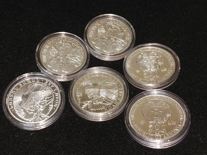 A collection of six silver coins, some in clear plastic capsules, displayed on a dark background, featuring text like 'REPUBLIC OF ARMENIA' and 'LIBERTE EGALITE FRATERNITE'.