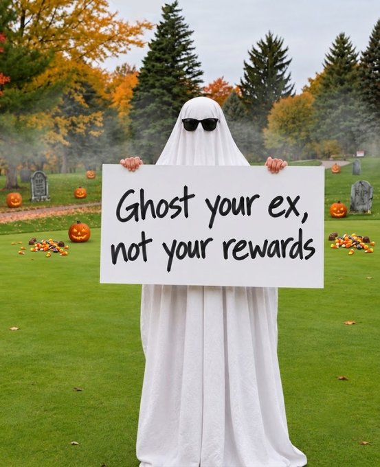 A person dressed as a ghost wearing sunglasses holds a sign reading, “Ghost your ex, not your rewards,” in an autumn graveyard scene with pumpkins and tombstones. The spooky “ghost” theme ties into the post’s Halloween-inspired pitch for unlocking up to 1,000 $WORLD daily through Profit Sharing and other activities.