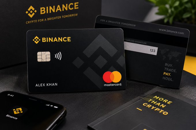 A black Binance Card issued under the name "ALEX KHAN" rests next to its branded box and a smartphone displaying the Binance app, showcasing a Mastercard-powered crypto payment solution. The card features a chip, contactless symbol, and the tagline "BUY. TRADE. PAY. HODL." — visually reinforcing the post's point about making crypto usable for everyday spending.