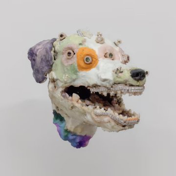 A colorful ceramic sculpture of a dog's head with textured, multicolored glaze featuring multiple eyes and an open mouth showing teeth.