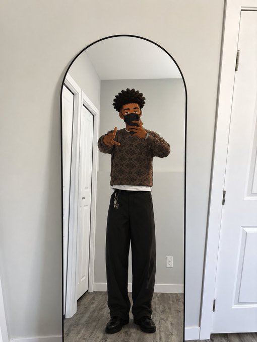 A person taking a mirror selfie in a brown patterned sweater and black trousers with keys hanging from their pocket, paired with a "gm winners" caption highlighting $RIVER's ecosystem growth and @TheARCTERMINAL's sovereign AI vision.