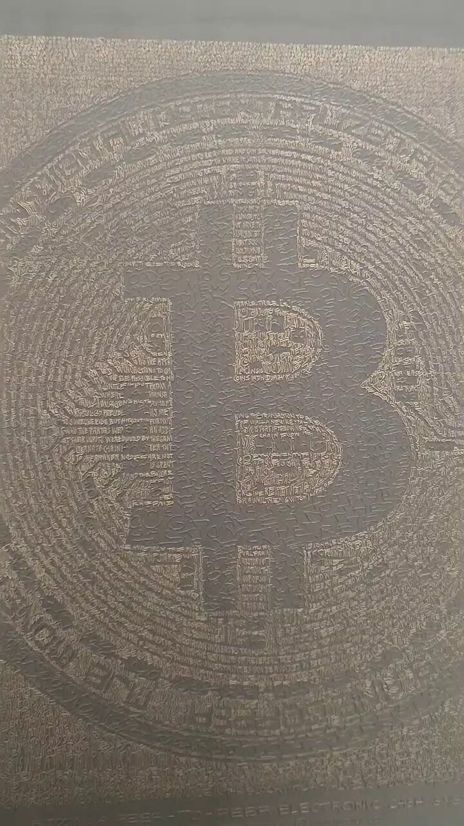 The image features a wooden surface with a large, circular engraving of the letter "B" in black letters against a gold background. The engraving appears to be made from wood or maple, giving it an antique look. The text on the image reads "Zoom in and you can read the whitepaper".