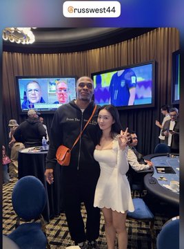 The image shows a tall man posing with a young woman in a white dress at what appears to be a poker or gaming event, with an Instagram handle "@russwest44" displayed at the top. The caption notes encountering "idol Wei Shao" (Russell Westbrook's Chinese nickname) and references his #NBA career alongside poker, suggesting this is a chance meeting with the basketball star at a poker tournament.